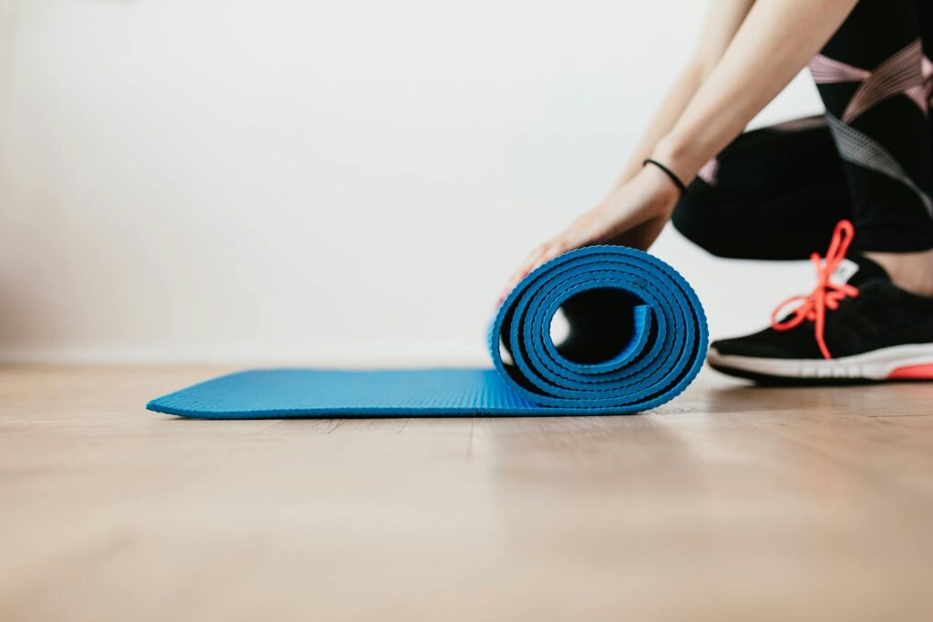 Fotografía de una chica enrollando una esterilla de pilates