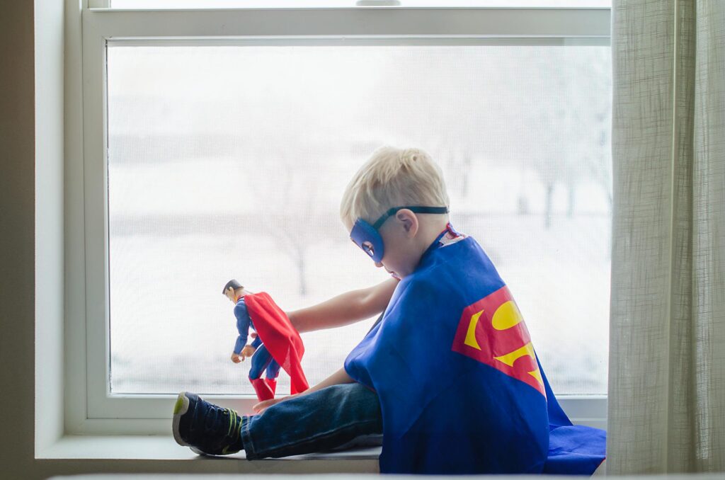 Fotografía de un niño vestido de Superman jugando